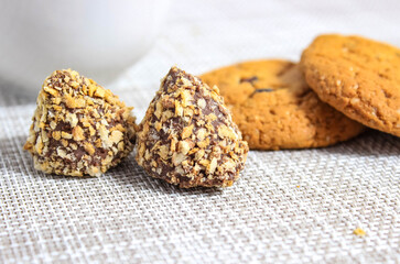 Candy truffle close-up on the table with oatmeal cookies in the background.