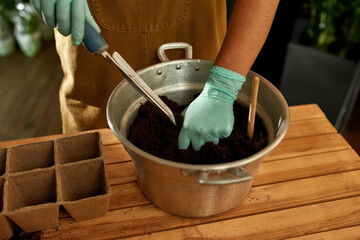 Girl standing at a table with a bucket of earth
