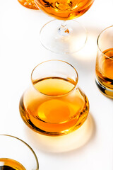 Hard strong alcoholic drinks, spirits and distillates in glasses: vodka, cognac, tequila, scotch, brandy and whiskey, grappa, vermouth, rum. White background