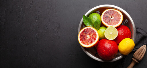 Various fresh citrus fruits in colander. Bood orange, lime, lemon
