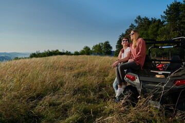 Naklejka na ściany i meble couple enjoying beautiful sunny day while driving a off road buggy