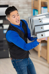 stressed businessman messing with folders