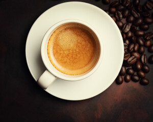 White cup of coffee and coffee bean on dark background. Copy space. Top view.