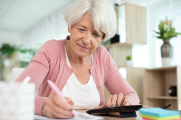 senior woman with calculator working on her finances