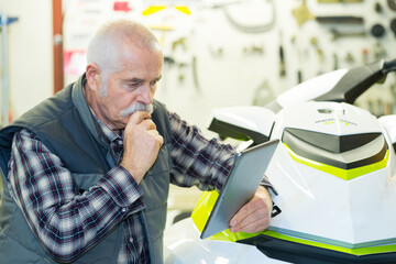 senior mechanic repairing jet ski in his workshop