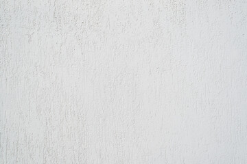 White wall finished with decorative plaster for outdoor use. Textured background with scratches