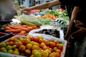 buying fresh vegetables on traditional market. customer at traditional market