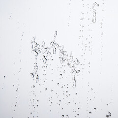 Fototapeta na wymiar Water Drops Background. Macro view of icy rain drops on the window creating abstract geometric graphic shapes. Close Up