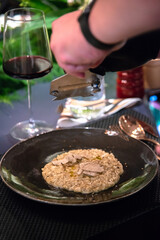 chef slide black truffles on risotto
