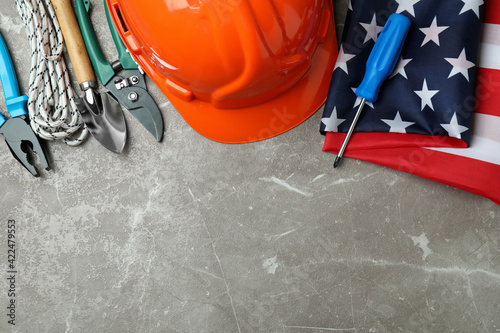 Concept of Labor Day with different construction tools on gray textured background