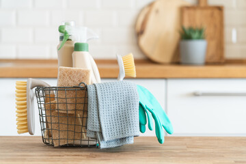 Basket with brushes, rags, natural sponges and cleaning products. Modern kitchen interior in the...
