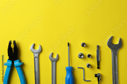 Flat lay with working tools on yellow background