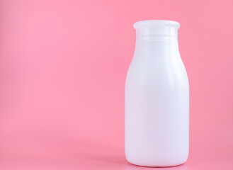 White plastic bottle for hygiene, cosmetics on a pink background. Packaging, layout, template. Copy space for text.