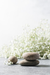 Cosmetic podium made of stones with flowers in the background. Natural background for product presentation