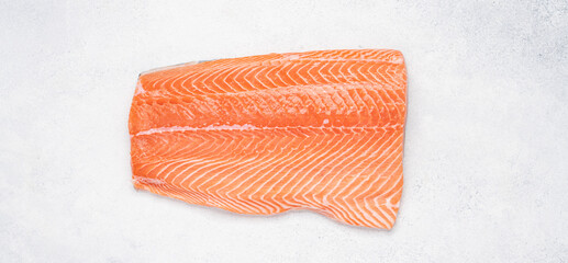 Raw salmon fillet on white stone background. Healthy fresh seafood. Close-up top view. Banner size