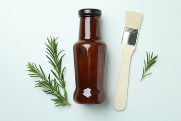 Barbecue sauce, rosemary and brush on white background