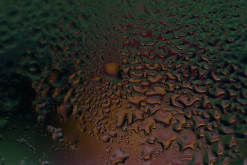 water drops on wet window glass with city lights