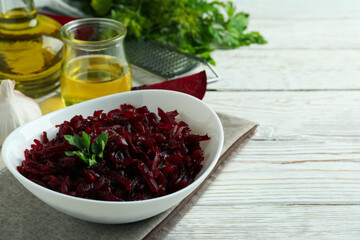 Concept of tasty eating with beet salad on white wooden background