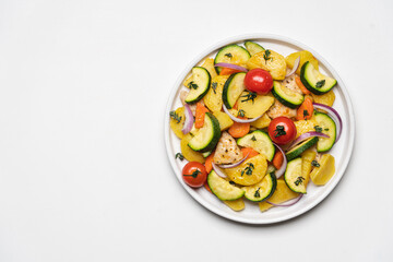 Baked vegetables and meat in plate on white background. Cooked dish of Potatoes, zucchini, carrots, onions, tomato and chicken