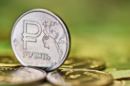 One rouble coin among other ruble coins against green background. Russian money