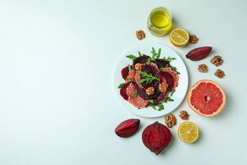 Plate of tasty beet salad and ingredients on white background