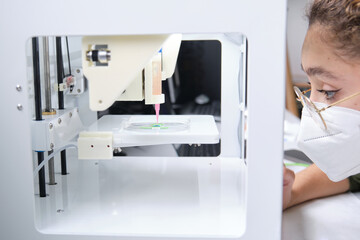 Researcher adjusting a 3D bioprinter to 3D print cells onto an electrode. Biomaterials, tissue...