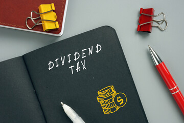 Business concept meaning DIVIDEND TAX with inscription on the page. A dividend tax is...