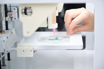 Researcher getting 3D bioprinter ready to 3D print cells onto an electrode. Biomaterials, tissue...