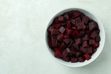 Bowl with fresh beet salad on white textured background