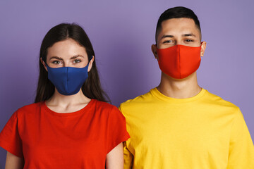 Brunette happy couple in face mask looking at camera