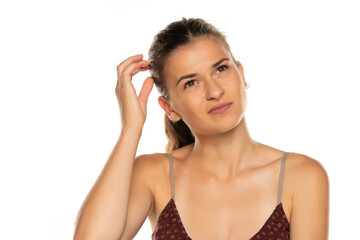 Young woman scratching her head. 