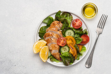 Chopped chicken breast with salad. Lettuce, tomatoes, cucumbers with poultry. Healthy eating food on white background