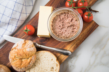 Grobe Leberwurst im Glas aus Vorrat mit Brötchen, Butter und Tomaten als Vesper Brotzeit auf...