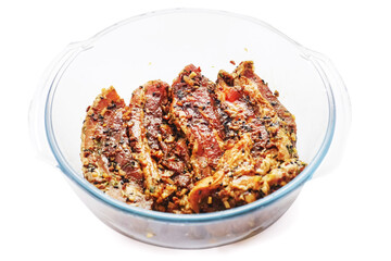 Korean style marinated pork belly slices in a glass bowl on white isolated background. Meat industry product.