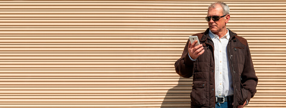 man with sunglasses using mobile phone in the city