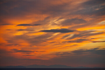 Fototapeta na wymiar The fantastic pastel colors of the clouds at sunset in an ocean bay