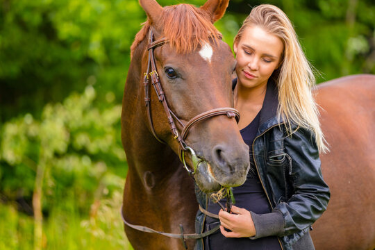 Beautiful young woman with her arabian horse in the field