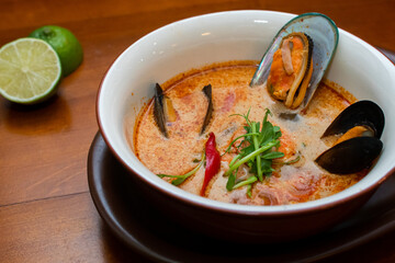 Tom Yam kung Spicy Thai soup with seafood, coconut milk and chili pepper 