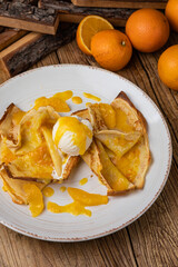 Pancakes with orange jam and ice cream on a large white plate
