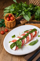 Mozzarella, tomatoes, basil sauce on a white plate
