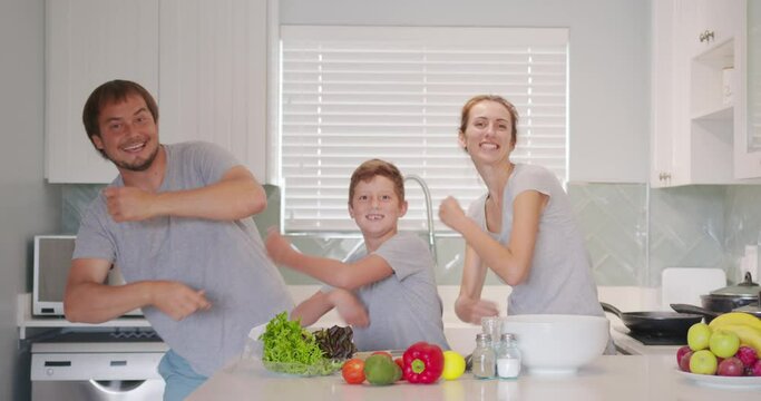 Funny Happy Family And Cute Children Having Fun Dancing In Kitchen Together, Active Mom Dad Enjoying Funky Dance With Son.