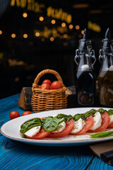 Mozzarella, tomatoes, basil sauce on a white plate
