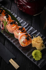 Japanese rolls on a dark plate in a restaurant
