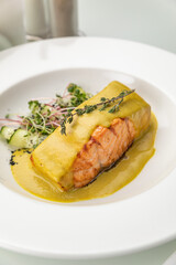 Salmon in sauce on a white plate
