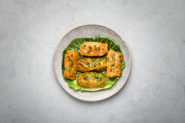 Golubtsi or golabki on gray plate on concrete table top. Stuffed cabbage rolls dish of russian, polish, ukrainian cuisine. European food.