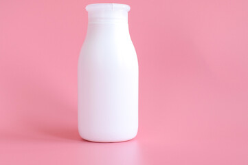 White plastic bottle for hygiene, cosmetics on a pink background. Packaging, layout, template. Copy space for text.