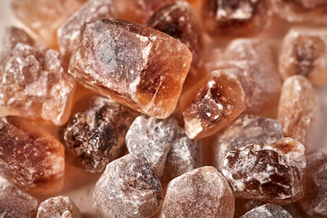 Brown caramelized lump cane sugar cubes, selective focus macro, food background