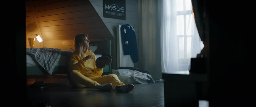WIDE Attractive Caucasian teenager girl playing baseball catch with herself in her attic bedroom at home. Shot with 2x anamorphic lens