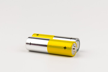 Photo of gray-yellow alkaline AA batteries on white background. Recycling of rechargeable NiMH batteries. The most popular size of accumulators. Copy space.