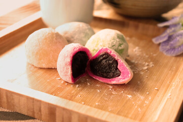 Daifuku Mochi stuffed with sweet red bean paste filling and put on the wooden tray. Vintage style photo.